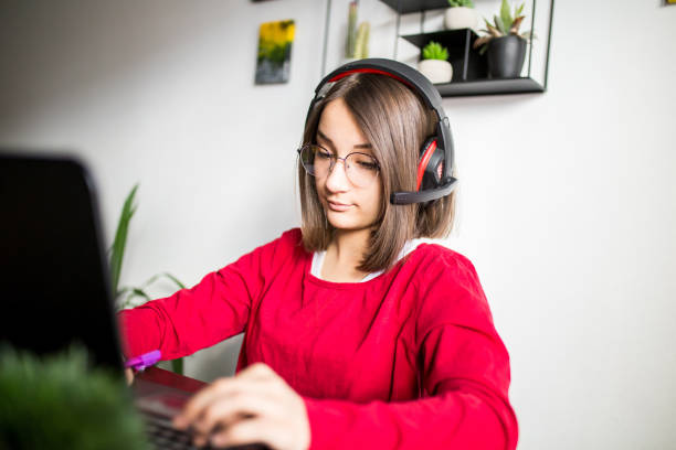 The young girl is at home and she is studying online